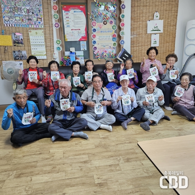 연풍면 괴정경로당에서 대한노인회 괴산군지회,‘지구를 지키는 엄마 가방’합동 프로그램으로 만든 가방과 함께 기념촬영을 하고 있다